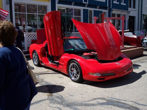 1972 Ford Ranchero - A red sports car with its hood and butterfly doors open is displayed outdoors. The vehicle's year is not discernible from the image.