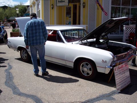 1972 Ford Ranchero - A white 1967 Chevrolet Chevelle SS is displayed with its hood open, showing the engine and a descriptive sign.