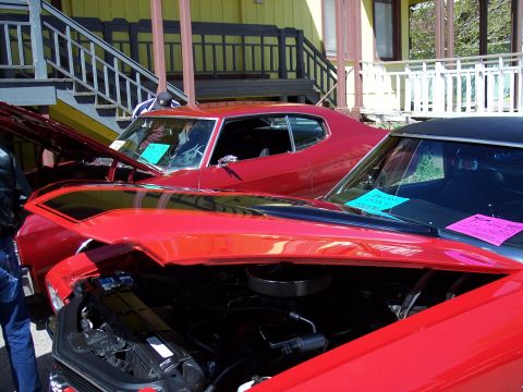 1972 Ford Ranchero - Two classic cars are displayed with their hoods up, showing off their engines.