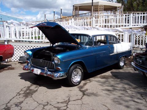 1972 Ford Ranchero - A classic blue and white sedan is displayed with its hood open, parked outdoors on a paved area.