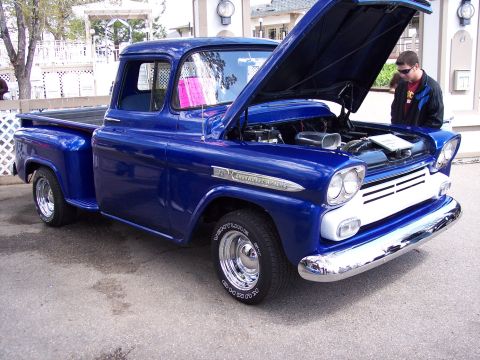 1972 Ford Ranchero - A bright blue 1957 Chevrolet pickup truck is displayed with its hood open, revealing the engine compartment.