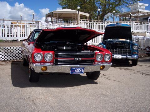 1972 Ford Ranchero - A red muscle car, possibly a 1972 Chevelle SS, is parked with its hood open, alongside another classic car.