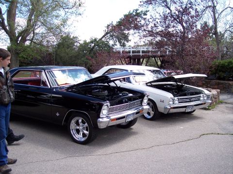 1972 Ford Ranchero - Two classic American coupes, a black Nova and a white Chevelle, are displayed with their engines visible.