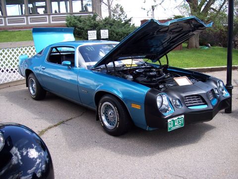 1972 Ford Ranchero - This blue coupe, likely a 1977 model, features an open hood revealing the engine and a prominent rear spoiler.