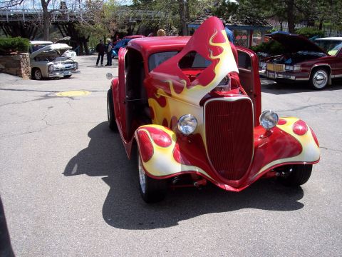 1972 Ford Ranchero - A custom hot rod with a flame paint job is displayed with its hood open, parked outdoors.