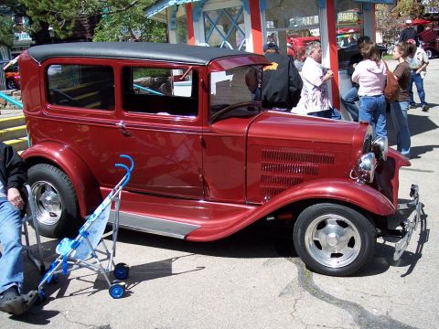1972 Ford Ranchero - A maroon 1930s sedan is parked outdoors with people in the background.