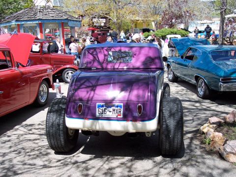 1972 Ford Ranchero - A row of classic cars are parked outdoors, with a vibrant purple hot rod in the foreground.