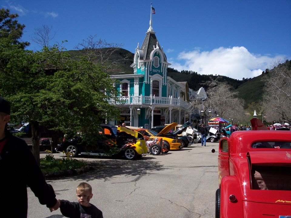 Cars lined up on a street in front of old buildings, with a child in the foreground