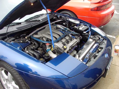 1989 Ford Probe - Engine bay of a blue 1989 Ford Probe, with another Probe in the background.