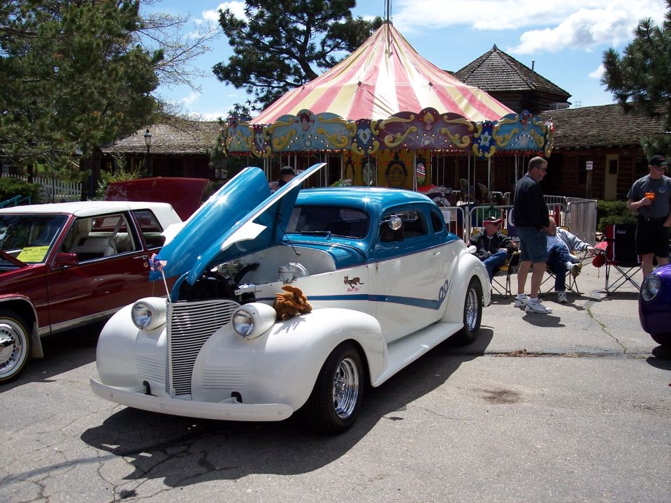 White and blue coupe with hood open, chrome wheels, and a black cat decal on the side