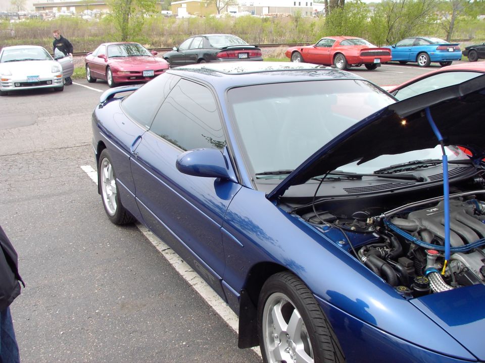 Blue 1989 Ford Probe with hood open, parked in lot with other cars