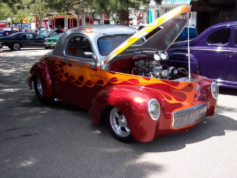 1972 Ford Ranchero - Custom hot rod with flame paint and exposed engine at an outdoor car show.