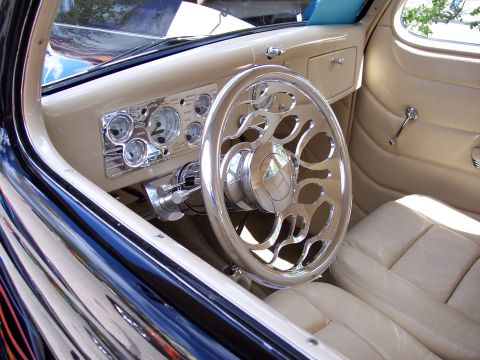 1972 Ford Ranchero - The interior of a classic car features a highly customized dashboard and steering wheel with a tan leather interior.