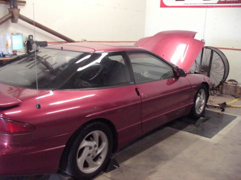 1989 Ford Probe - 1989 Ford Probe undergoing testing on a dynamometer in a garage setting.