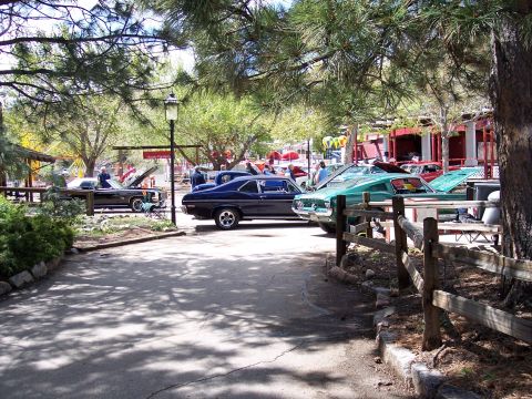 1972 Ford Ranchero - A gathering of vintage automobiles displayed outdoors under trees, with people milling about.