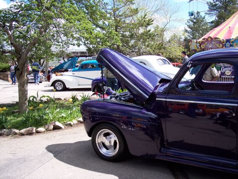 1972 Ford Ranchero - A purple classic car is parked next to a white and blue two-tone vehicle at an outdoor event.