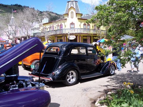 1972 Ford Ranchero - Several custom cars are on display in front of a historic building.