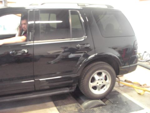 1989 Ford Probe - A black SUV is positioned on a dynamometer, with a person visible inside the vehicle.