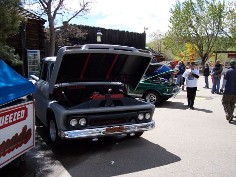 1972 Ford Ranchero - A gray GMC pickup truck is parked next to a green car at an outdoor event.
