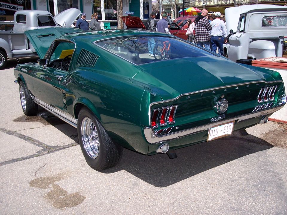 Green fastback coupe rear view. License plate reads 01B-E15