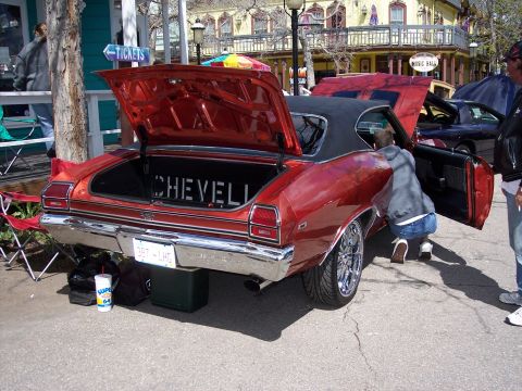 1972 Ford Ranchero - A red 1970 Chevrolet Chevelle SS is parked with its trunk and driver's door open.