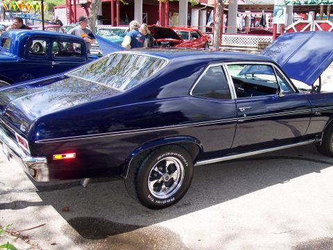 1972 Ford Ranchero - A dark blue coupe, possibly a 1970 Nova, is parked at an outdoor event with its hood open.
