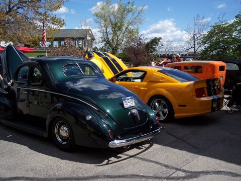 1972 Ford Ranchero - A vintage green coupe is parked next to a yellow sports car and an orange hot rod.