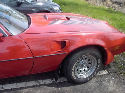 1989 Ford Probe - A red car with a T/A 6.6 decal on its hood is parked next to another vehicle.