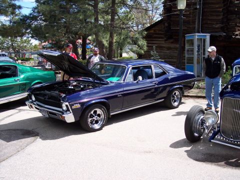 1972 Ford Ranchero - A dark blue 1970 Chevrolet Nova coupe is displayed with its hood open at an outdoor event.