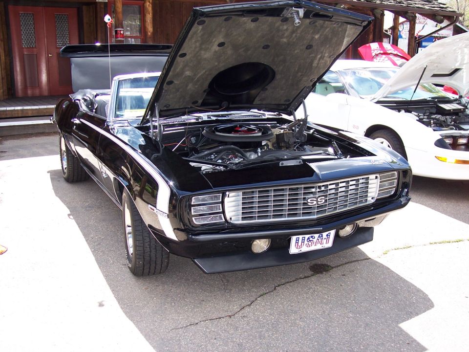 1969 Chevrolet Camaro SS convertible with hood open, parked next to a white car