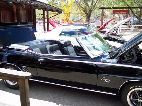 1972 Ford Ranchero - A black 1969 Camaro SS convertible is parked next to other cars with hoods up.