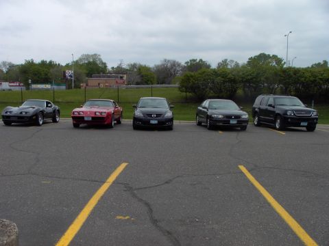 1989 Ford Probe - A collection of five vehicles parked in an outdoor lot under an overcast sky.