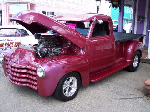 1972 Ford Ranchero - Customized pickup truck with a supercharged engine on display, parked next to a Chevrolet Camaro.