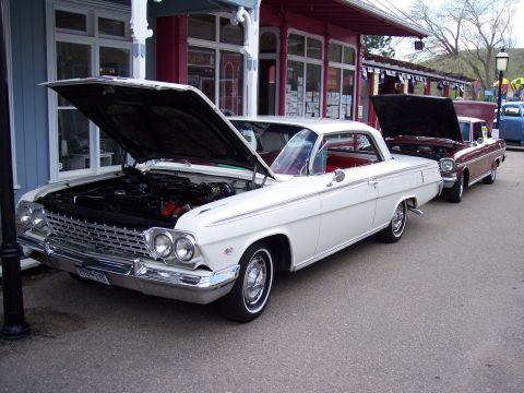1972 Ford Ranchero - Two classic cars, a white 1962 Chevrolet Impala and a maroon Chevrolet Nova, are parked with their hoods up.