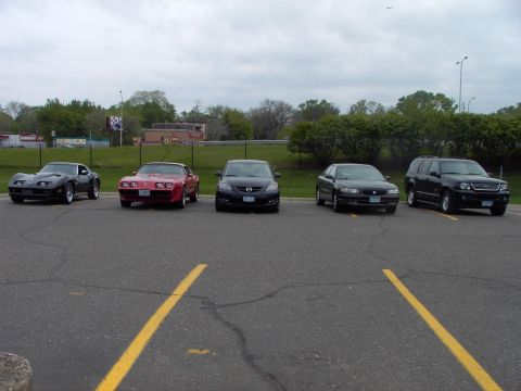 1989 Ford Probe - Multiple vehicles are parked in an asphalt lot under an overcast sky.