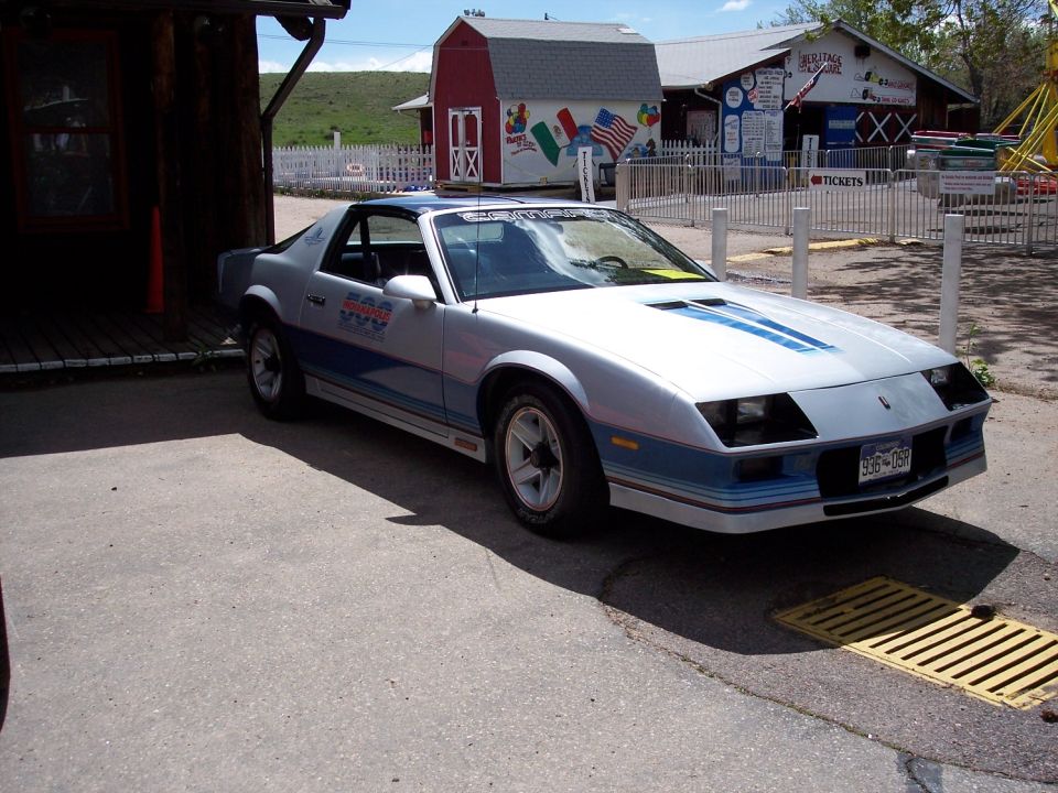 Silver and blue sports coupe with racing stripes and racing decals on the door
