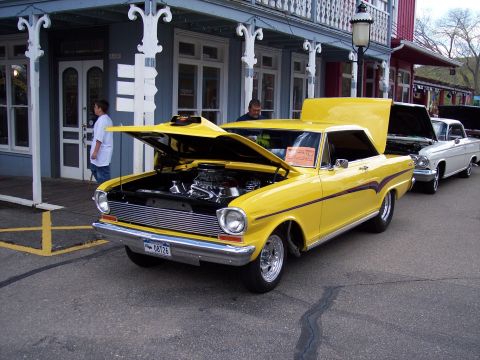 1972 Ford Ranchero - A bright yellow classic car is displayed with its hood up, revealing the engine compartment.