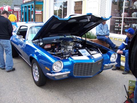 1972 Ford Ranchero - A blue muscle car with its hood open, displaying its engine and chrome wheels.