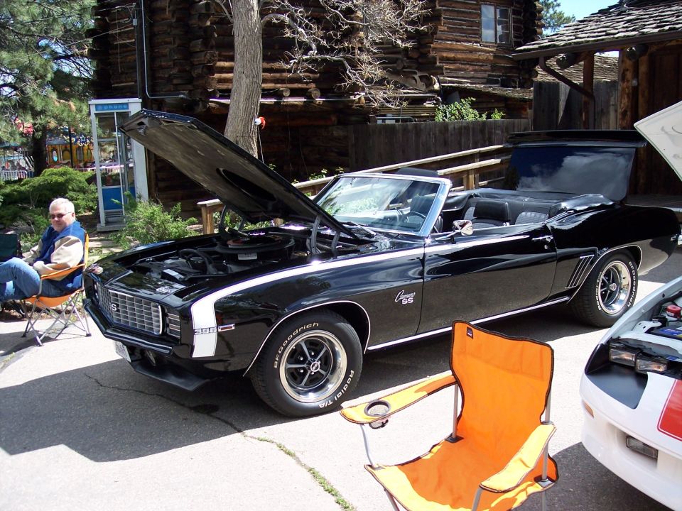 Black 1969 Camaro SS convertible with hood open, white racing stripes