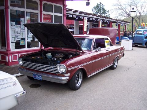 1972 Ford Ranchero - A maroon 1966 Chevrolet Nova is displayed with its hood open, parked outdoors near other vehicles.