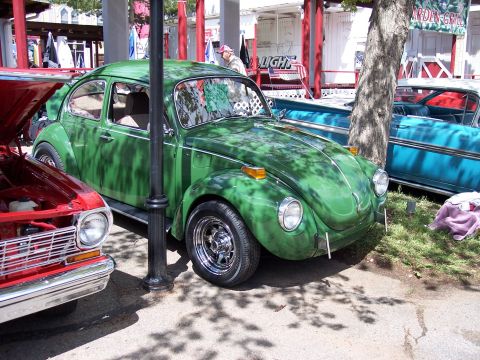 1972 Ford Ranchero - A green Volkswagen Beetle is parked outdoors, with other vehicles visible in the background.