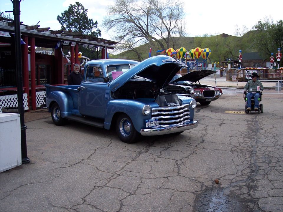 Blue 1950s pickup truck front view, hood open. License plate reads S23-170