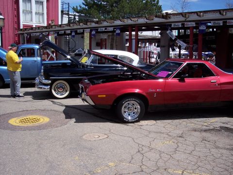 1972 Ford Ranchero - A red 1972 Ford Ranchero is displayed with its hood open, parked next to other classic vehicles.