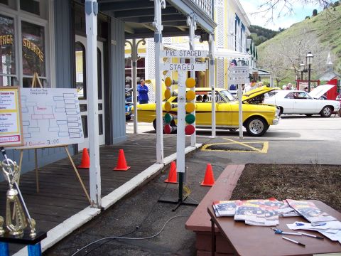 1972 Ford Ranchero - A yellow drag car is staged next to a white car, with a bracket racing championship board visible.