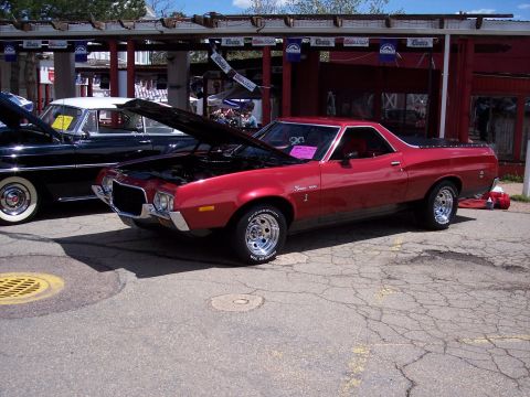 1972 Ford Ranchero - A red 1972 Ford Ranchero is displayed with its hood up, parked alongside another vehicle.
