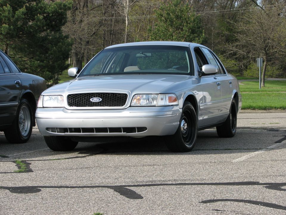 Silver 2003 Ford Crown Victoria with black steel wheels parked on asphalt