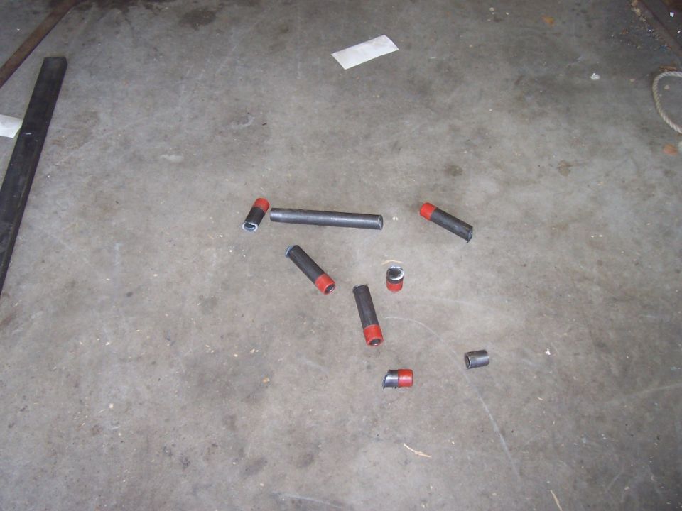 Several metal tubes, some with red caps, scattered on a concrete floor