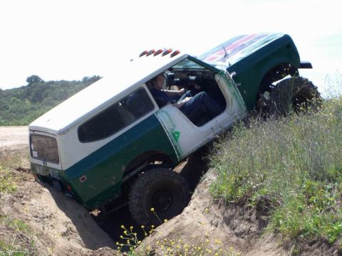 1980 Ford F-250 - Off-roading vehicle is stuck in a ditch with its tires digging into the dirt.