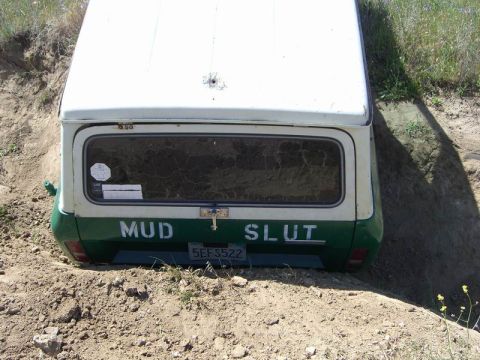 1980 Ford F-250 - This van appears to be stuck in a dirt ditch, with custom text painted on its rear.