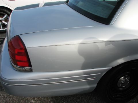 2003 Ford Crown Victoria - Close-up view of the rear section of a silver sedan, showing the taillight and body lines.